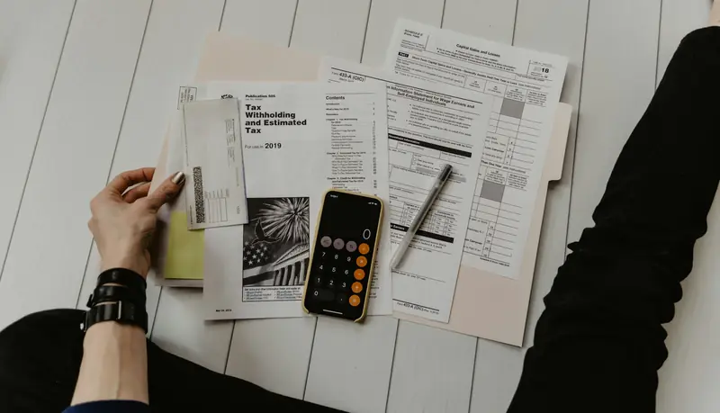 Group health insurance renewal paperwork and a calculator on a desk