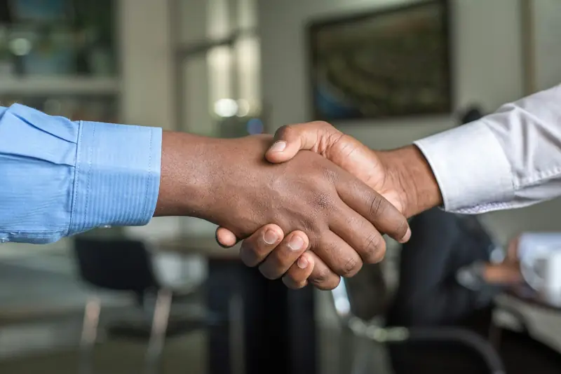 An insurance agent shaking hands with a business owner