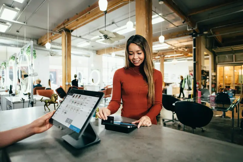 A small business owner helping a customer at a point-of-sale register